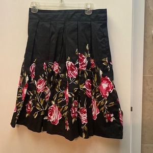 Super flattering black knee length skirt with gorgeous pink roses. Size M